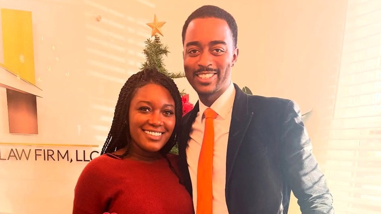 Paige and Justin smiling in front of a Christmas tree