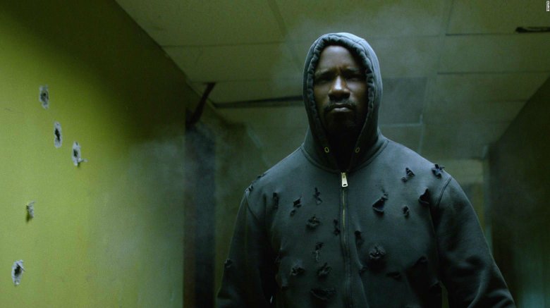 Mike Colter as Luke Cage; wearing a hoodie riddled with bullets