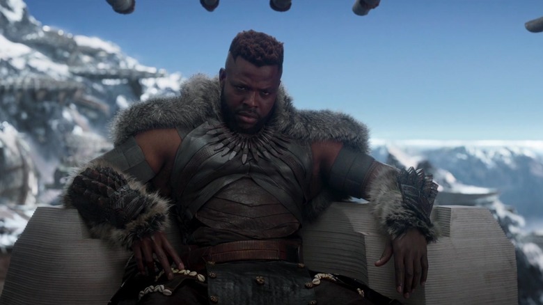 M'Baku sitting in fur with mountains behind him