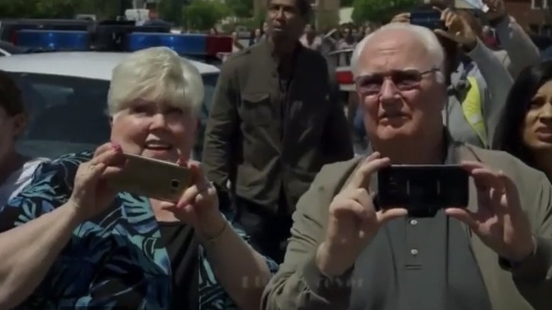 Two people film with phones
