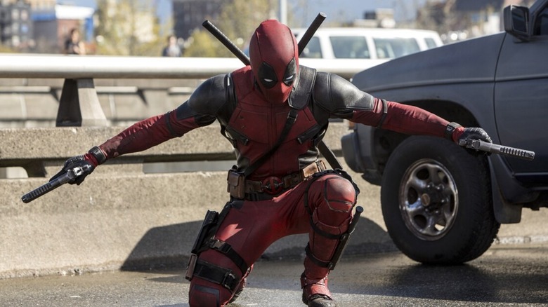 Deadpool crouches with guns