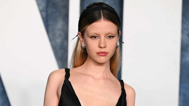 Mia Goth looks on