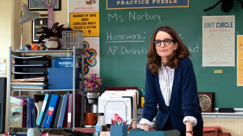 Ms. Norbury smiling behind desk