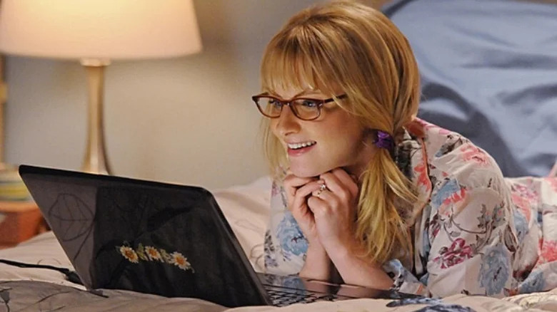 Melissa Rauch as Bernadette on her laptop in bed in The Big Bang Theory