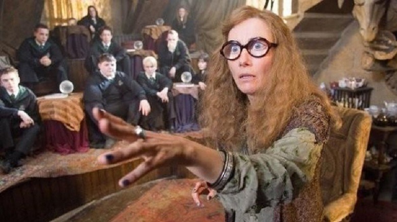 Professor Trelawney looks wide-eyed with her hand outstretched as a class of students look on in the background