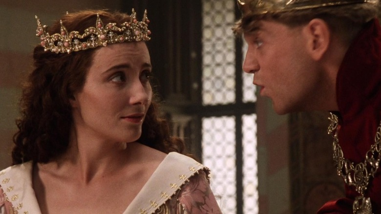 Henry V leans in close to speak to Princess Katharine, who smiles at him