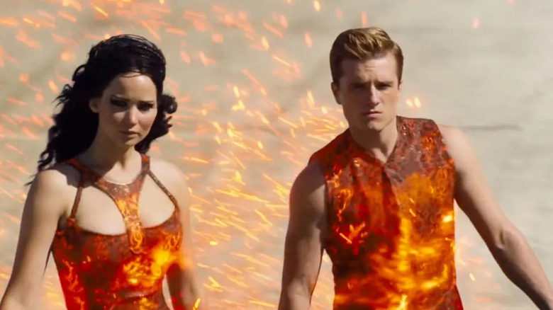 Katniss and Peeta in matching outfits on fire