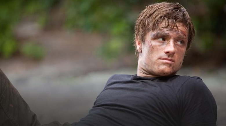 Peeta sitting on a beach with his leg propped up