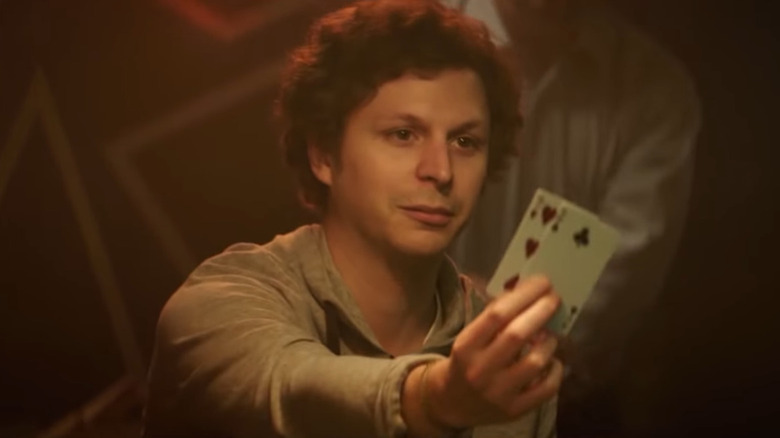 Michael Cera holds up playing cards