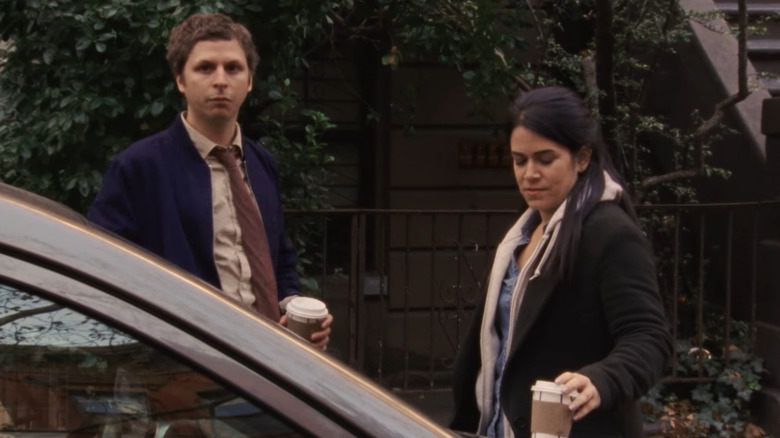 Michael Cera and Abbi Jacobsen stand next to a car