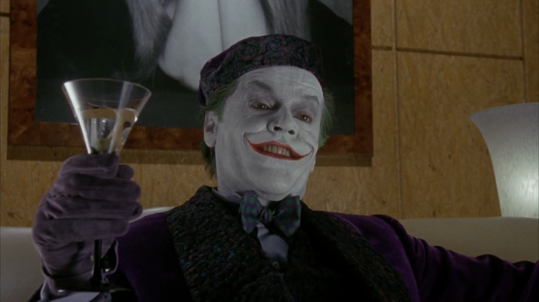 Joker smiling holding a martini glass