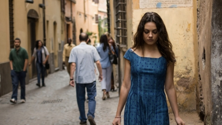 Mila Kunis walks down a busy street