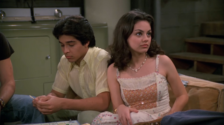 Jackie sitting next to Fez in the basement