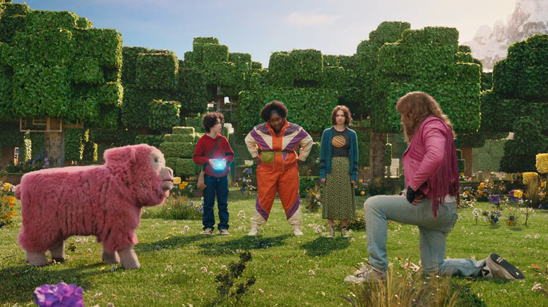 Garrett kneels before a pink sheep in "A Minecraft Movie" (2025)