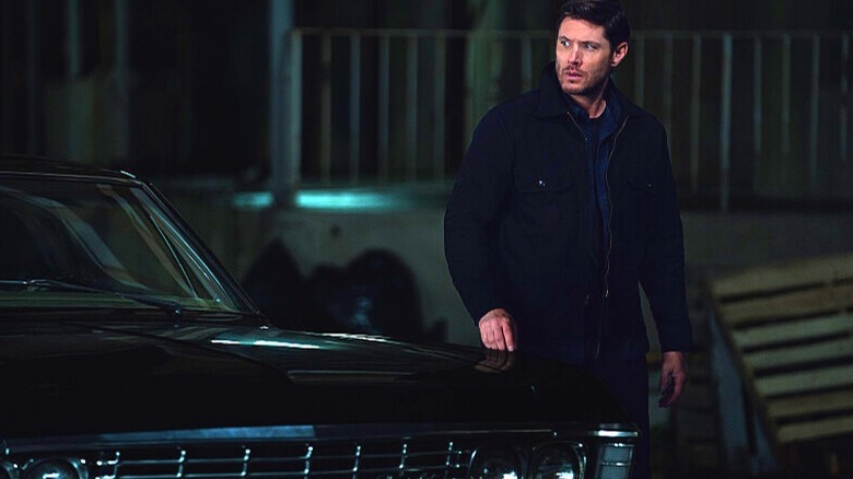 Dean Winchester standing next to his car