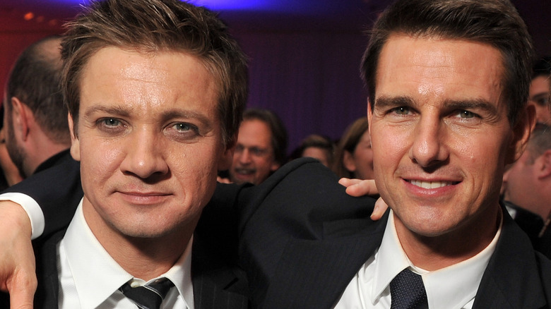 Tom Cruise and Jeremy Renner at event smiling