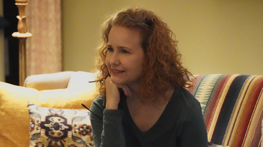 Molly Hagan sitting on a striped couch