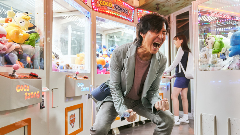 Lee Jung-jae as Seong Gi-hun, celebrating in an arcade