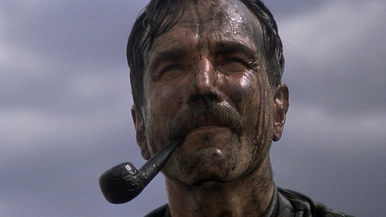 Daniel Plainview smiles covered in oil