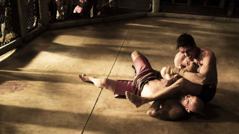 two men wrestle in a cage match