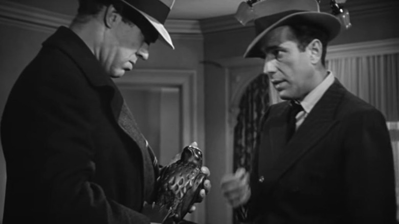 Humphry Bogart handing over Maltese Falcon