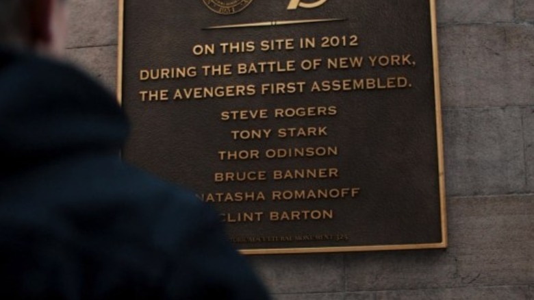 Clint standing next to Avengers memorial