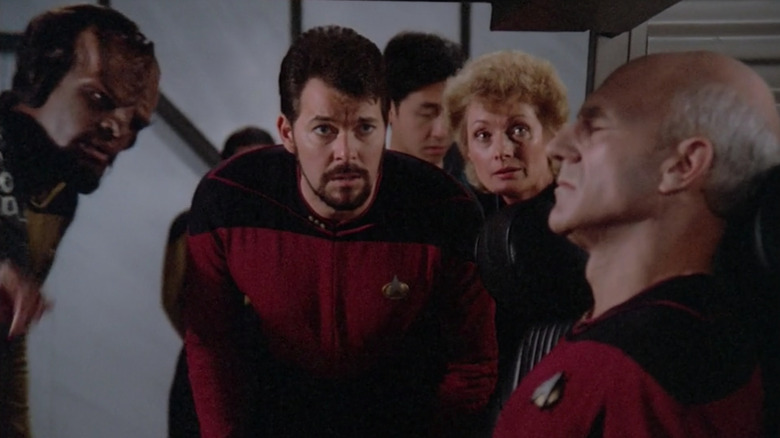 Riker, Pulaski and Worf look at a duplicate Picard