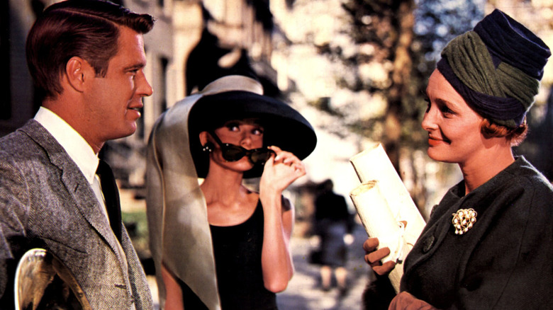 Holly Golightly lowers sunglasses and listens