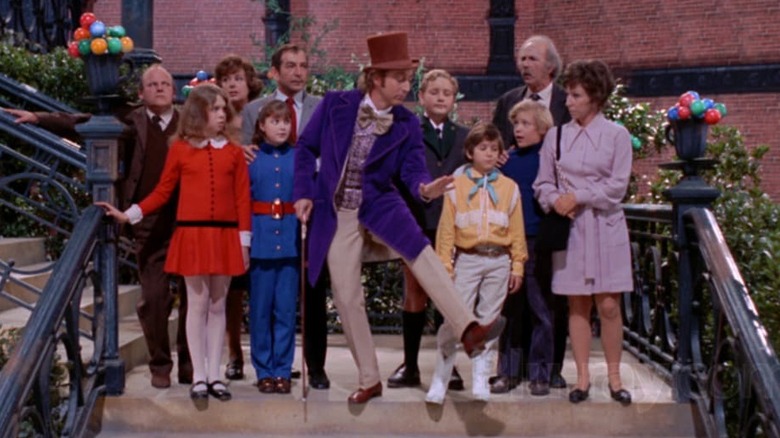 Willy Wonka dancing down stairs with group