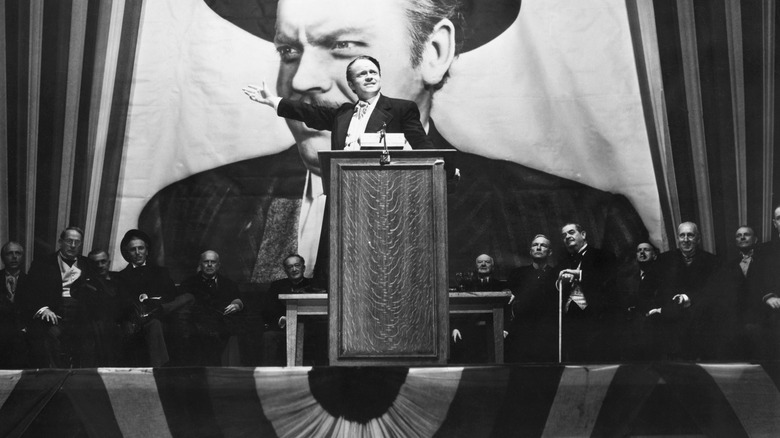 Charles Foster Kane behind a podium