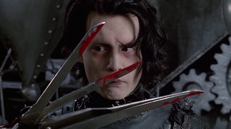 Edward Scissorhands holds up bloody scissors