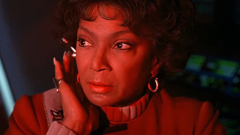 Uhura listens to her earpiece