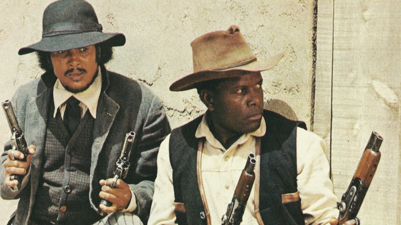 Buck and the Preacher each holding two guns