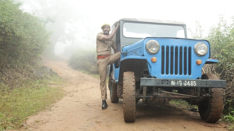 Man exits blue jeep