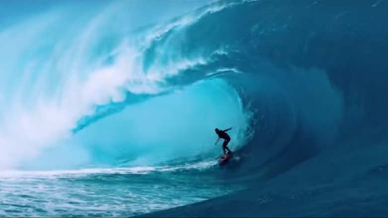 Surfer underneath huge wave