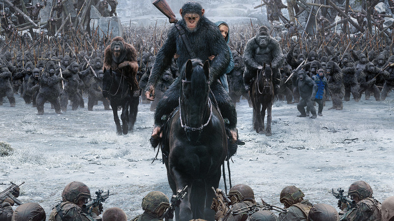 Apes ride on horseback toward soldiers