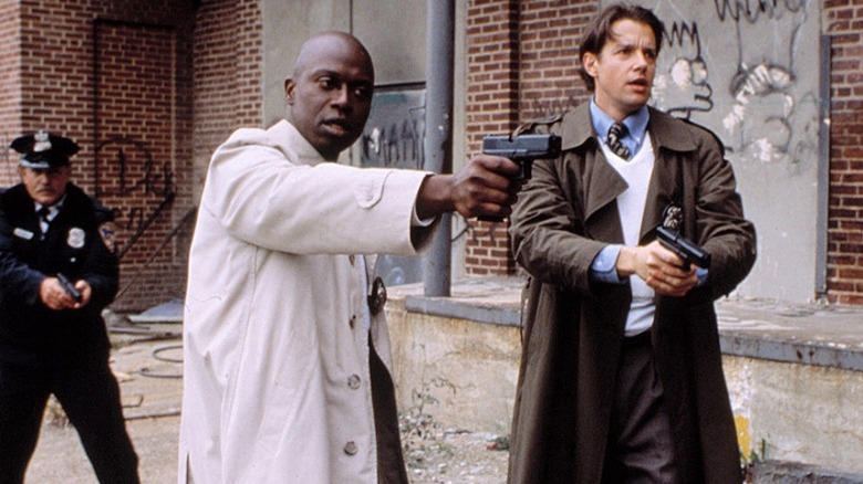 Andre Braugher aiming a gun with other police officers