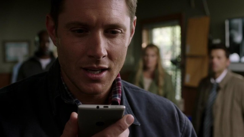 Dean Winchester looks at his cell phone in "Supernatural"