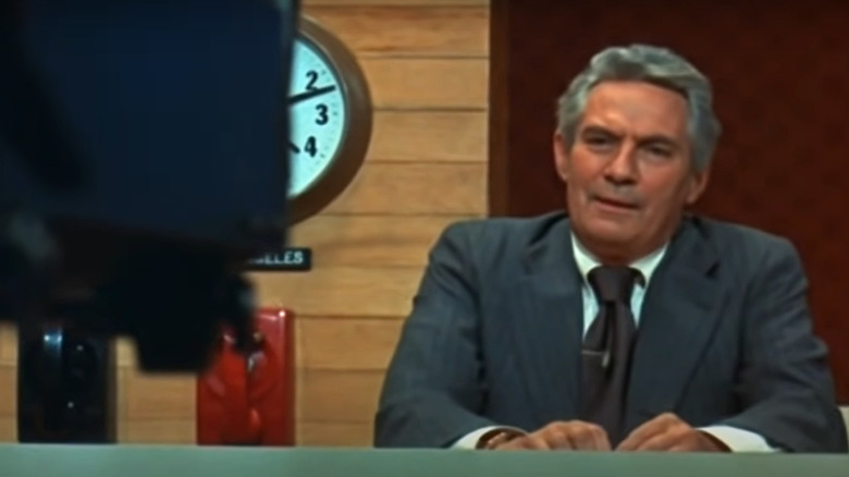 Howard Beale at news desk in Network