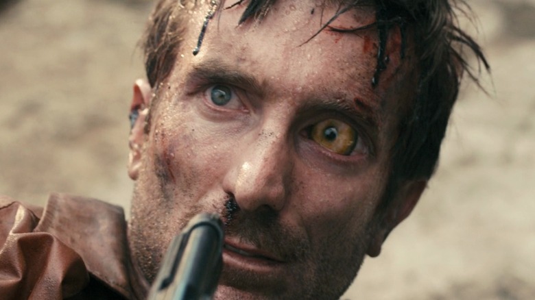 Sharlto Copley stares at gun 