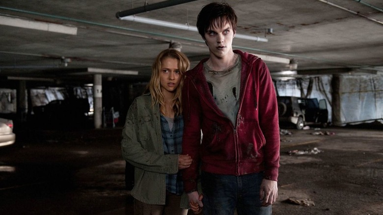 R the zombie (Nicholas Hoult) protects human Julie (Teresa Palmer) in Warm Bodies.