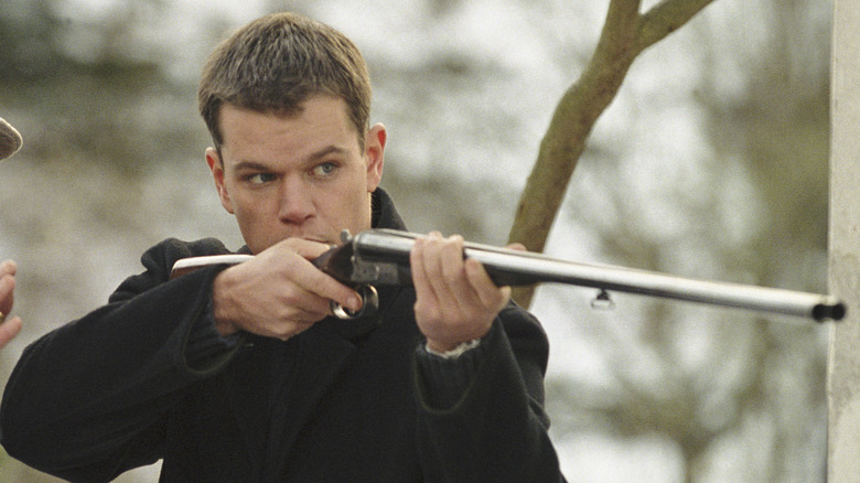 Jason Bourne holding rifle