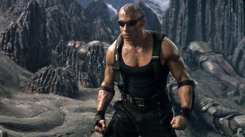 Riddick walks through an alien canyon