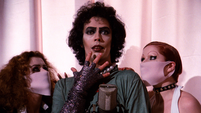 Frank N Furter flanked by his nurses