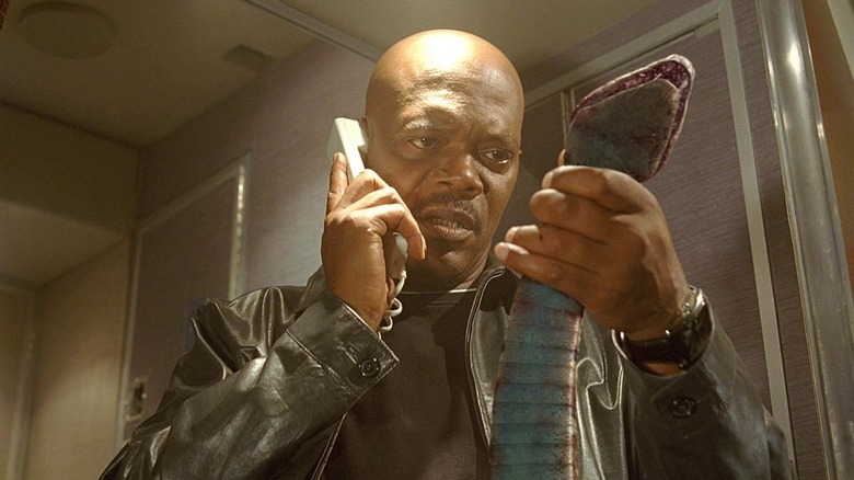 Sam Jackson holds a snake while on the phone