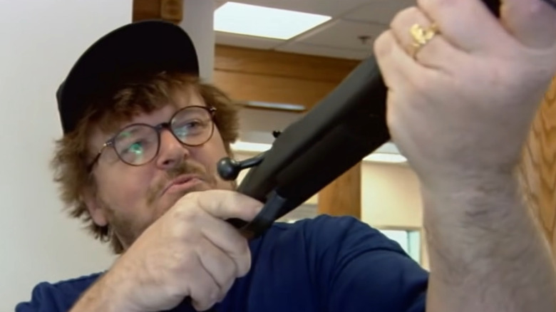 Michael Moore inspects rifle