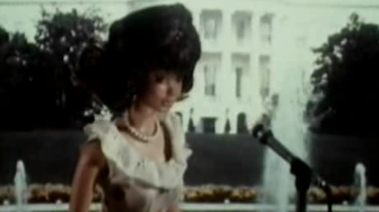 A Barbie doll representing Karen Carpenter speaks into a microphone in "Superstar"