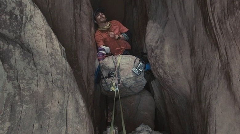 Aron Ralston sits on a rock