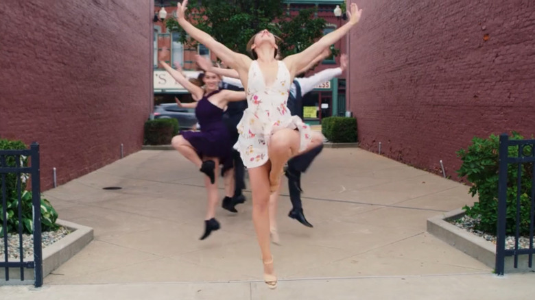 Group of men and women dancing on sidewalk