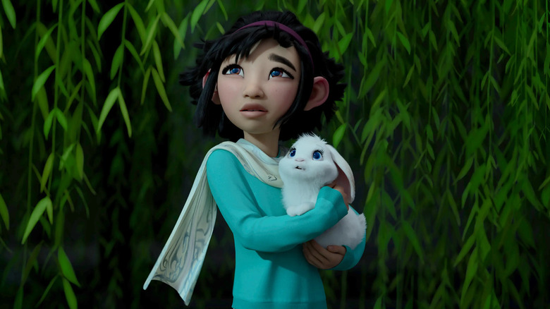 Fei Fei holds a rabbit in the field